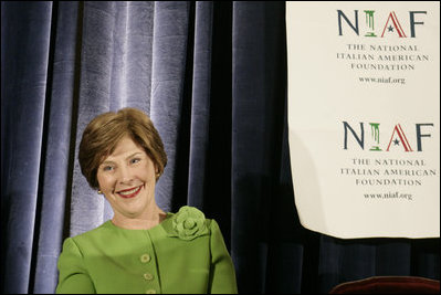 Mrs. Laura Bush smiles as she listens to an introduction by Dr. Ken Ciongoli , chairman of The National Italian American Foundation, during an education luncheon honoring Mrs. Bush with the NIAF Special Achievement Award in Literacy, Friday, Oct. 12, 2007 in Washington, D.C. In thanking the organization Mrs. Bush emphasized the many contributions that Italian-Americans have made in the education of our nation's youth.