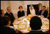 Mrs. Laura Bush speaks with guests at her table during the Iftaar Dinner with Ambassadors and Muslim leaders in the State Dining Room of the White House, Monday, Oct. 4, 2007.