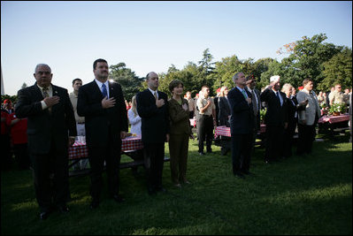President George W. Bush and Laura Bush stand for the singing of the National Anthem during a visit with military support organizations Tuesday, Sept. 18, 2007, on the South Lawn.