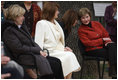 Mrs. Laura Bush leans in to listen to Alexandra Coman, fiance of Romania's Foreign Minister Adrian Cioroianu, as they join other guests, including Mrs. Maria Basescu, in white, spouse of Romania's President Taian Basescu, and Mrs. Jeannie de Hoop Scheffer, spouse of NATO Secretary General Jaap de Hoop Scheffer, at the Dimitrie Gusti Village museum in Bucharest.