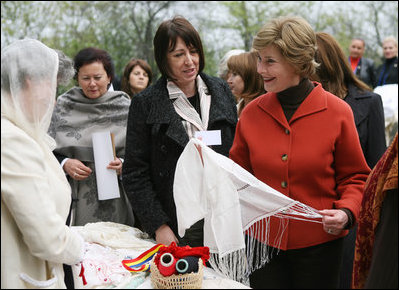Mrs. Laura Bush spends a moment with a traditional handicraft artisan at the Dimitrie Gusti Village during an outing Thursday, April 3, 2008, with NATO spouses to the Bucharest open-air museum.