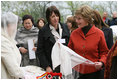 Mrs. Laura Bush spends a moment with a traditional handicraft artisan at the Dimitrie Gusti Village during an outing Thursday, April 3, 2008, with NATO spouses to the Bucharest open-air museum.