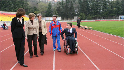 Mrs. Laura Bush walks on the track of Central Sochi Stadium Sunday, April 6, 2008, with Mr. Mikhail Terentyev, Secretary General of the Russian Paralympic Committee, Ms. Lisa Carty, spouse of the U.S. Ambassador to Russia William Burns, and Mrs. Irina Gromova, Coach of the Russian Paralympic team.