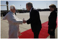President George W. Bush takes the hand of Pope Benedict XVI as he and Mrs. Laura Bush welcomed the Pope to the United States upon his landing at Andrews Air Force Base, Maryland. Pope Benedict will visit the White House Wednesday and celebrate Mass Thursday before continuing on to New York City.