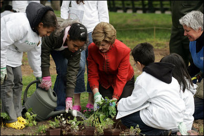 Mrs. Laura Bush helps children plant flowers at the First Bloom Event, Monday, April 21, 2008, during her visit to celebrate National Park week at the Castle Clinton National Monument in New York City.