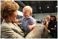 Mrs. Laura Bush receives a smile from a young boy as she greets the audience Monday, Aug. 4, 2008, after remarks by the President at Eielson Air Force Base, Alaska, their first stop en route to Asia.