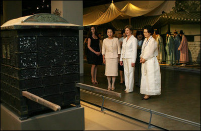 Mrs. Laura Bush is taken on a tour of the National Folk Museum of Korea by Mrs. Kim Yoon-ok, to the left of Mrs. Bush. On the August 6, 2008, visit to Seoul is Mrs. Bush's daughter, Ms. Barbara Bush, at left in black. The tour is led by Ms Yi, Ki Won, right, Deputy Director of Cultural Exchange and Education at the museum.