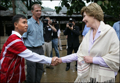 Mrs. Laura Bush is greeted as she prepares to enter a school at the Mae La Refugee Camp in Mae Sot, Thailand, where an English grammar class is being taught. Her Aug. 7, 2008 visit to the camp which houses at least 39,000 Burmese refugees, highlighted the plight of a people who have struggled since the Aug. 8, 1988 crackdown that created dire conditions in their country 20 years ago. Many have moved on to the United States or other countries such as Canada, New Zealand or the Netherlands. Mrs. Bush encouraged other countries to help the Burmese as well.