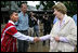 Mrs. Laura Bush is greeted as she prepares to enter a school at the Mae La Refugee Camp in Mae Sot, Thailand, where an English grammar class is being taught. Her Aug. 7, 2008 visit to the camp which houses at least 39,000 Burmese refugees, highlighted the plight of a people who have struggled since the Aug. 8, 1988 crackdown that created dire conditions in their country 20 years ago. Many have moved on to the United States or other countries such as Canada, New Zealand or the Netherlands. Mrs. Bush encouraged other countries to help the Burmese as well.
