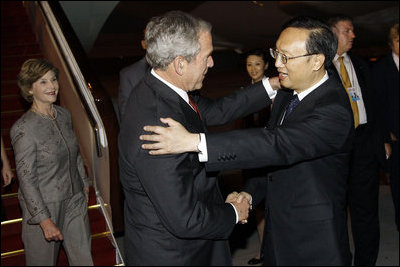 President George W. Bush and Mrs. Laura Bush are greeted by China's Foreign Minister Yang Jiechi, upon their arrival Thursday, Aug. 7, 2008, at Beijing Capitol International Airport in Beijing, where they will attend the opening ceremonies for the 2008 Summer Olympic Games on Friday.