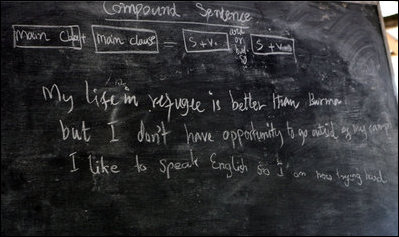 The English lesson on the chalkboard in a grammar class visited by Mrs. Laura Bush in Mae La Refugee Camp tells the story of the Burmese refugees and uses three lines to discuss compound sentence construction. It says " My life in refugee is better than Burma but I don't have opportunity to go outside of my camp. I like to speak English so I am now trying hard." The Aug. 7, 2008 visit to the camp in Mae Sot, Thailand, highlighted the fact that it has been 20 years since the crackdown in Burma that sent many people fleeing the dire conditions. Many residents have been born in one of the nine camps along the border or have lived most of their lives there.