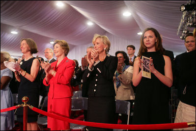 Mrs. Laura Bush stands with Mrs. Sarah Randt, spouse of U.S. Ambassador to China Sandy Randt, left, Mrs. Anne Johnson, Director of Art in Embassies Program, and Ms. Barbara Bush during applause for President George W. Bush Friday, Aug. 8, 2008, at the dedication ceremony for the U.S. Embassy in Beijing.