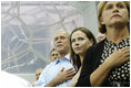President George W. Bush, daughter Barbara Bush and Mrs. Doro Koch, the President's sister, stand for the playing of the U.S. national anthem Sunday, Aug. 10, 2008, during the medal ceremony honoring gold medalist Michael Phelps. The U.S. Olympian won his first event, the 400-meter Individual Medley, in a record time of 4:3.84.