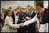 President George W. Bush looks at the U.S. Olympic jacket presented to him as Mrs. Laura Bush shakes hands with U.S. Olympic gold medalist Michael Phelps Sunday, Aug. 10, 2008, at the National Aquatics Center in Beijing.