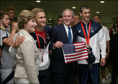 President George W. Bush and Mrs. Laura Bush pose for photos with U.S. Olympic swimmers Larsen Jensen, left, and Michael Phelps Sunday, Aug. 10, 2008, at the National Aquatics Center in Beijing.