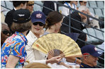 Mrs. Laura Bush wearing a U.S. Olympic baseball team hat uses a fan to keep cool as she watches the U.S. Olympic men's baseball team play a practice game against the Chinese Olympic men's baseball team Monday, Aug. 11, 2008, at the 2008 Summer Olympic Games in Beijing.