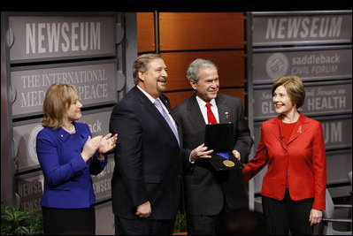 President George W. Bush, joined by Mrs. Laura Bush, is presented with the International Medal of PEACE by Pastor Rick Warren and his wife, Kay Warren, left, Monday, Dec. 1, 2008, following their partipation at the Saddleback Civil Forum on Global Health in Washington, D.C.