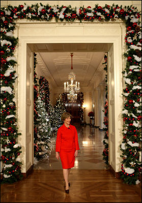 Mrs. Laura Bush walks from the White House Cross Hall into the East Room, Wednesday, Dec. 3, 2008, to begin the Christmas press preview of the White House decorations and preparations.