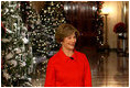 Mrs. Laura Bush walks from the White House Cross Hall into the East Room, Wednesday, Dec. 3, 2008, to begin the Christmas press preview of the White House decorations and preparations.