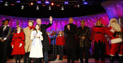 President George W. Bush and Mrs. Laura Bush stand on stage Thursday, Dec. 4, 2008, with Santa, entertainers and guests, during the 85th Lighting of the National Christmas Tree on the Ellipse in Washington, D.C. With them, from left, are: Members of Step Afrika!; Lindsey Van Horn, 9, and Kayleigh Kepler, 11, the official tree lighters; Phil Vassar; Jon Secada, and Santa and his elf.