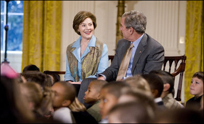 Mrs. Laura Bush and President George W. Bush sit with youngsters Monday, Dec. 8, 2008, during the Children's Holiday Reception and Performance in the East Room of the White House.