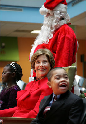 Mrs. Laura Bush watches Barney Cam VII: A Red, White & Blue Christmas as it debuts for children at Children's National Medical Center in Washington, D.C. on Dec. 15, 2008. With Mrs. Bush are her two patient escort volunteers, Dania Jecty, left, age 11, and Elmer Reyes, age 13. Visiting the hospital is an annual tradition for Mrs. Bush, and one she says she will miss.