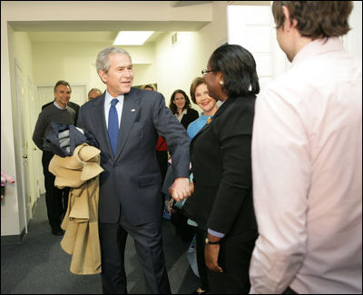 With Mrs. Laura Bush by his side, President George W. Bush speaks to reporters Monday, Dec. 22, 2008, during a visit to the Pathways to Housing DC, a distribution site for the One Warm Coat Holiday Service Project, in Washington, D.C. Modeled after the first Pathways to Housing program in New York City founded in 1992, Pathways to Housing DC works with individuals who have been turned away from other programs.