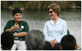 Mrs. Laura Bush smiles as a Florida City Elementary School student gives a thumbs-up while sitting on stage with Mrs. Bush, Wednesday, Feb. 6, 2008, during the Junior Ranger "First Bloom" planting event in Everglades National Park, Fla. Mrs. Bush praised the Everglades restoration program which will help bring back native trees in areas of the Everglades overgrown with non-native plants.