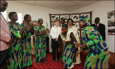 Mrs. Laura Bush and Madame Chantal de Souza Yayi, wife of President Boni Yayi of Benin, watch as representatives of the USAID-Supported Mothers' Association perform Saturday, Feb. 16, 2008, during their visit in Cotonou, Benin.