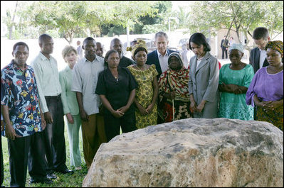 President George W. Bush and Mrs. Laura Bush, joined by U.S. Secretary of State Condoleezza Rice, stand with the family members of victims during a moment of silence Sunday, Feb. 17, 2008 in the memorial garden of the U.S. embassy in Dar es Salaam in Tanzania, in remembrance for those who died in the 1998 U.S. embassy bombing.