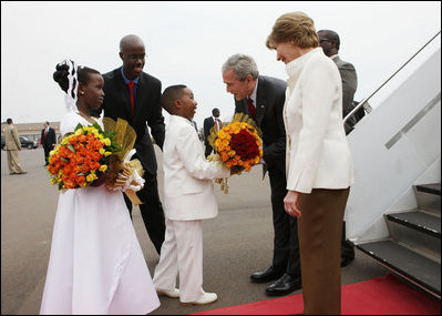 President George W. Bush and Mrs. Laura Bush are greeted by children with flowers on their arrival Tuesday, Feb. 19, 2008 to Kigali International Airport in Kigali, Rwanda.