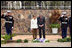 Flanked by saluting U.S. Marines President George W. Bush and Mrs. Laura Bush pause for a moment of silence after laying a wreath on a mass grave at the genocide memorial Tuesday, Feb. 19, 2008, at the Kigali Memorial Centre in Kigali, Rwanda.