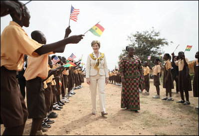Mrs. Laura Bush and Ghana first lady Mrs. Theresa Kufuor, are greeted by singing students waving flags, on their arrival to Mallam D/A Primary School, Wednesday, Feb. 20, 2008 in Accra, Ghana.