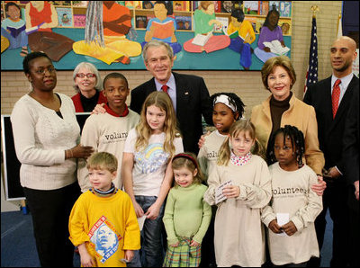 President George W. Bush and Laura Bush are joined by Washington, D.C. Mayor Adrian Fenty, right, and Ginnie Cooper,Chief Librarian for the Washington, D.C. libraries, left, posing for photos with children and staff at a reading class commemorating Martin Luther King Day Monday, Jan. 21, 2008, at the Martin Luther King Jr. Memorial Library.