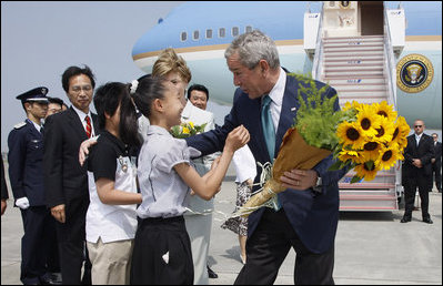 President George W. Bush and Laura Bush accept flowers from young greeters upon their arrival Sunday, July 6, 2008 to the New Chitose International Airport, to attend the Group of Eight Summit in Toyako, Japan.