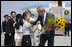 President George W. Bush and Laura Bush accept flowers from young greeters upon their arrival Sunday, July 6, 2008 to the New Chitose International Airport, to attend the Group of Eight Summit in Toyako, Japan.