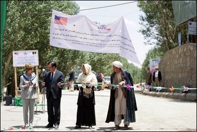 Mrs. Laura Bush, left, assists local officials with the ribbon cutting ceremony June 9, 2008 in Afghanistan at the ground-breaking ceremonies for the 1.96 kilometer Bamiyan road project through the bazaar. The new road will link up with a 1.72 kilometer road from the airport to the town center completed in 2007 with U.S. support.