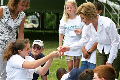 Mrs. Laura Bush takes a closer looks at a flower during a First Bloom planting event at Charlestown Navy Yard Sunday, June 22, 2008 in Boston, MA. Students of the Boys and Girls Club of Boston and Warren Prescott Elementary School participated in a three-day workshop that focused on invasive species, native plants, seed cultivation, garden design, and monitoring species.