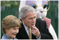 President George W. Bush embraces Mrs. Laura Bush as he blows a whistle Monday, March 24, 2008 on the South Lawn of the White House, to officially start the festivities for the 2008 White House Easter Egg Roll.