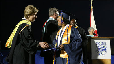 Mrs. Laura Bush congratulates a graduate during commencement exercises Thursday, May 29, 2008, at Enterprise High School in Enterprise, Alabama. Mrs. Bush was on hand to deliver the commencement address, and she told the class -- that lost four of its members in deadly tornadoes last year -- and told the Class of 2008, "As you graduate tonight, take with you memories of your teachers' and classmates' support after the storm, the blue and white worn by students at rival schools, and the donations that came pouring in from around the country."