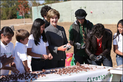 Surrounded by children Mrs. Laura Bush practices making seed balls during a First Bloom event at the Trinity River Audubon Center, Sunday, November 2, 2008, in Dallas, TX. Mrs. Bush is joined by singer/songwriters the Jonas Brothers, Kevin Jonas, Joe Jonas, and Nick Jonas, right.