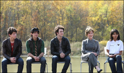 Mrs. Laura Bush is joined onstage by Boys and Girls Club student Jovanna Moreno age 11, right, and singer/songwriters the Jonas Brothers, Nick Jonas age 16, left, Joe Jonas age 19, 2nd from left, and Kevin Jonas age 20, 3rd left during a First Bloom event at the Trinity River Audubon Center, Sunday, November 2, 2008, in Dallas, TX.