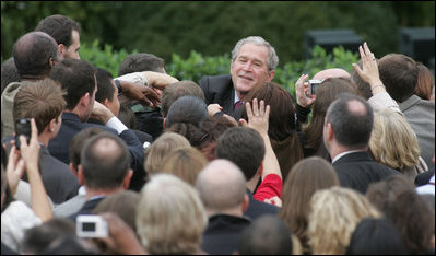 President George W. Bush reaches out to staff members of the Executive Office of the President Thursday, Nov. 6, 2008, after speaking to them on the upcoming presidential transition. The President was joined by his Cabinet, Vice President and Mrs. Cheney and Mrs. Laura Bush as he told his staff, "As January 20th draws near, some of you may be anxious about finding a new job, or a new place to live... But between now and then, we must keep our attention on the task at hand -- because the American people expect no less."