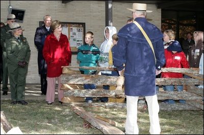 Mrs. Laura Bush watches with children as a reenactor demonstrates rail splitting during her visit to the Abraham Lincoln Birthplace National Historical Site Tuesday, Nov. 18, 2008, in Hodgenville, KY.