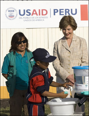 Mrs. Laura Bush and Ms. Nancy Quispitupa, Program Manager and Community Trainer, watch as 8-year-old William Sebastian Hernandez Jeri demonstrates learned hand-washing techniques Friday, Nov. 21, 2008, at the San Clemente Health Center in San Clemente, Peru. The center is the town's major health provider and serves an average of 80 patients per day.