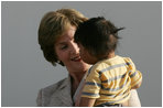 Mrs. Laura Bush smiles as she holds a child during a visit Friday, Nov. 21, 2008, to the San Clemente Health Center in San Clemente, Peru. The center serves an average of 80 patients a day in the town of 25,000 located six miles north of Pisco, the site of the August 2007, 8.0-magnitude earthquake.