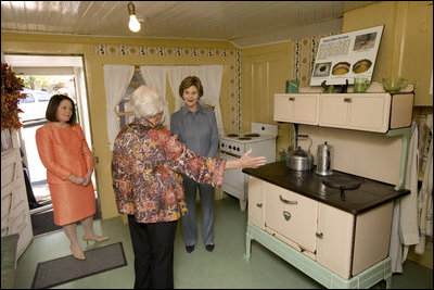 Mrs. Laura Bush receives an explanation of the scale of author Laura Ingalls Wilder's kitchen from Mrs. Jean Coday, Director and President of the Laura Ingalls Wilder Historic Home and Museum in Mansfield, Mo., Oct. 3, 2008. Accompanying the two on the tour is Mrs. Melanie Blunt, First Lady of Missouri. Wilder is one of Mrs. Bush's favorite writers and she was surprised to see the petite kitchen, built to function for the 4-foot-10-inch author.