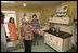 Mrs. Laura Bush receives an explanation of the scale of author Laura Ingalls Wilder's kitchen from Mrs. Jean Coday, Director and President of the Laura Ingalls Wilder Historic Home and Museum in Mansfield, Mo., Oct. 3, 2008. Accompanying the two on the tour is Mrs. Melanie Blunt, First Lady of Missouri. Wilder is one of Mrs. Bush's favorite writers and she was surprised to see the petite kitchen, built to function for the 4-foot-10-inch author.