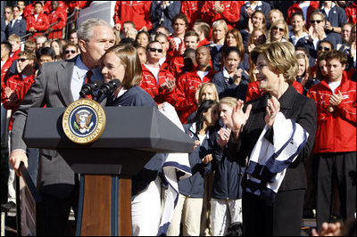 President George W. Bush kisses Army Lieutenant Melissa Stockwell, Paralympian and Iraq war veteran, after she presents President Bush and Mrs. Laura Bush with the American Flag that flew over the Olympic Village in Beijing following his remarks to members of the 2008 United States Summer Olympic and Paralympic Teams Tuesday, Oct. 7, 2008, on the South Lawn of the White House.