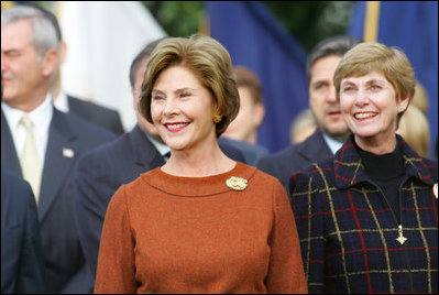 Mrs. Laura Bush and Mrs. Deborah Mullen, wife of the Chairman of the Joint Chiefs of Staff, Admiral Mike Mullen, watch the White House South Lawn ceremonies Oct. 13, 2008, for the State Arrival of Italian Prime Minister Silvio Berlusconi.